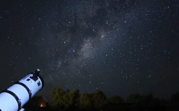 Observación astronómica con telescopio en el valle
